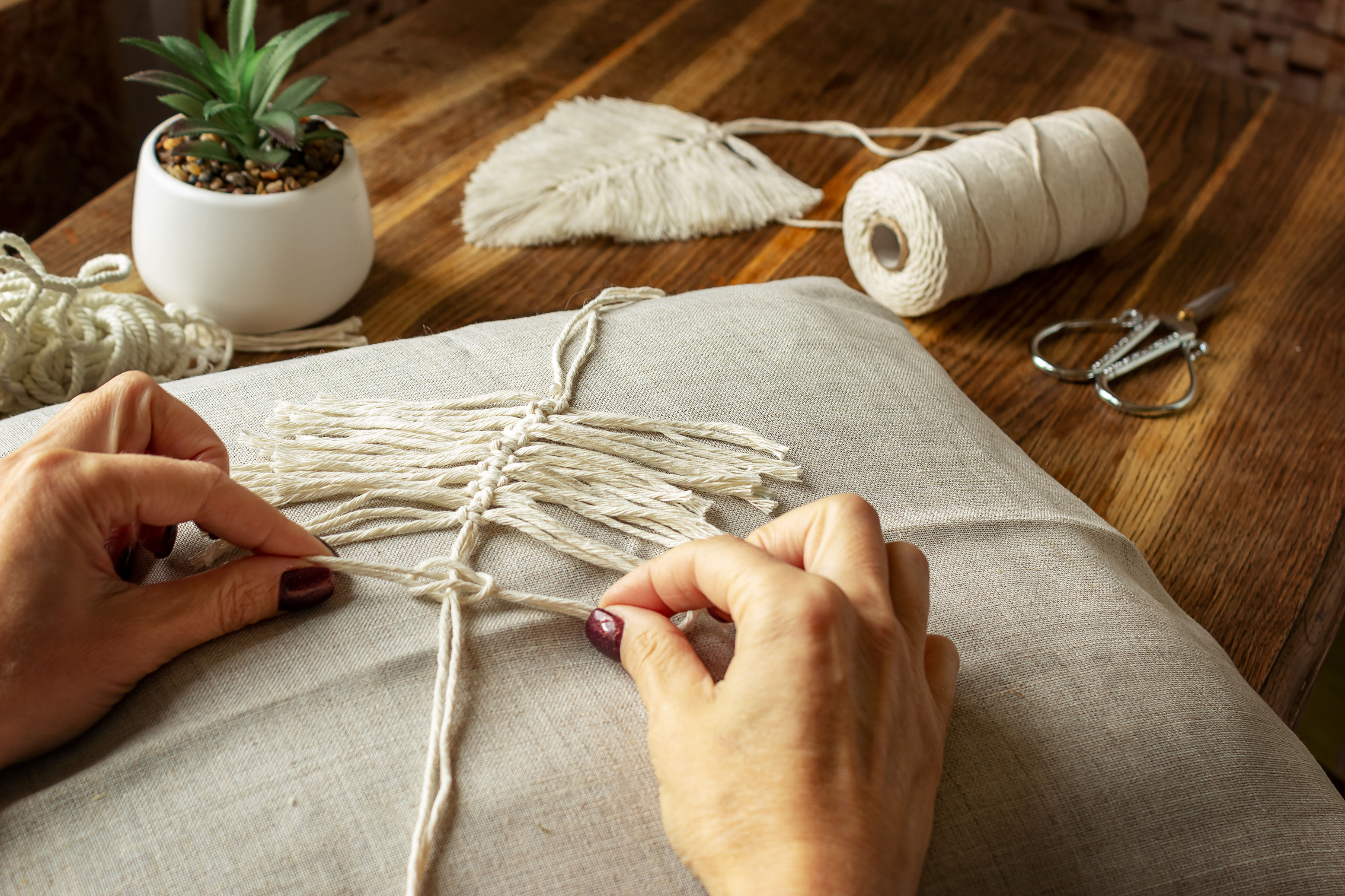 Weaving macrame at home. Woman's hand when she makes macrame.